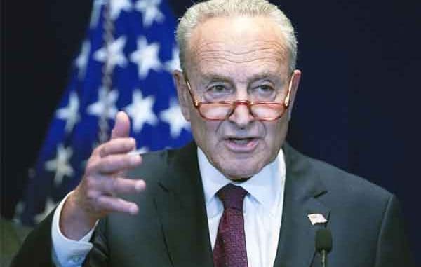 Chuck Schumer speaking in front of an American flag